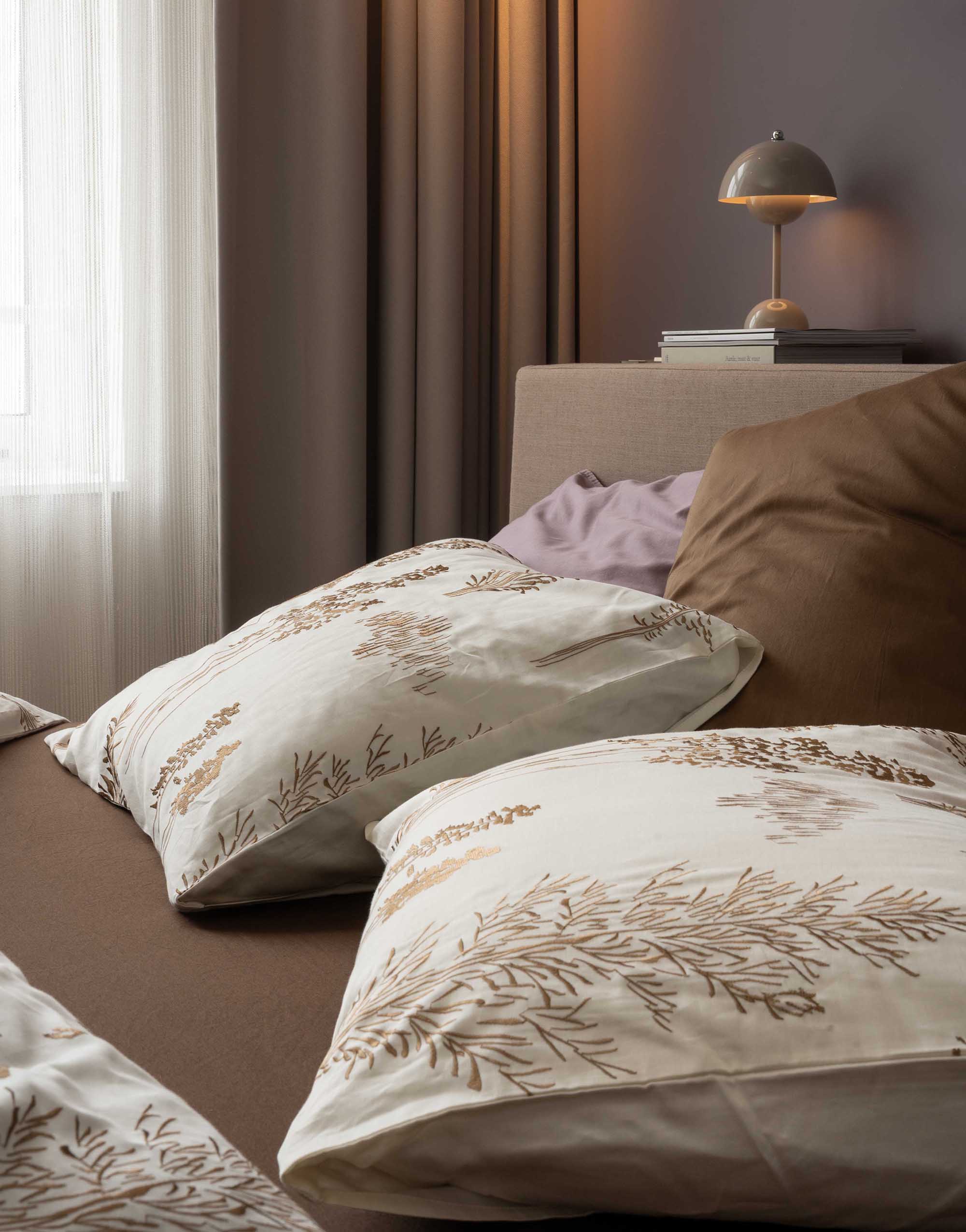Opgemaakt bed met een gekleurd hoeslaken onder een dekbedovertrek